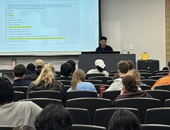 Students in a lecture hall at an ESA midterm prep session, with practice questions on the projector