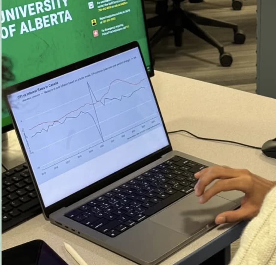 A laptop showing a chart of CPI versus interest rates in Canada at an ESA workshop